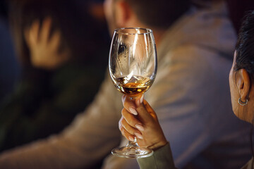 Close-Up of an Attendee Sampling Wine at Tasting Course in an Evening Setting