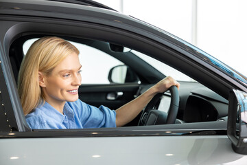 Blonde woman in a blue shirt in a new car