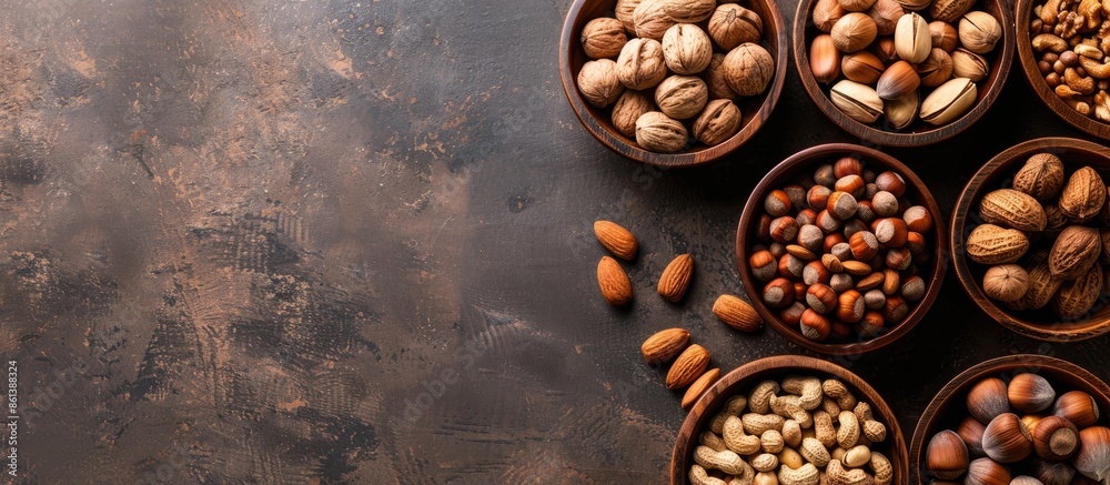 Poster Top view of different types of nuts placed in wooden bowls against a copy space image.