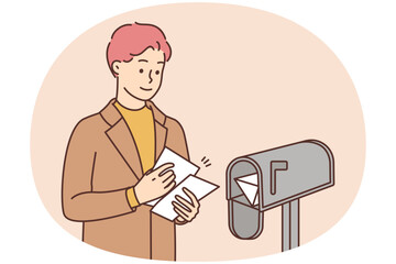 Smiling man put letters in letterbox