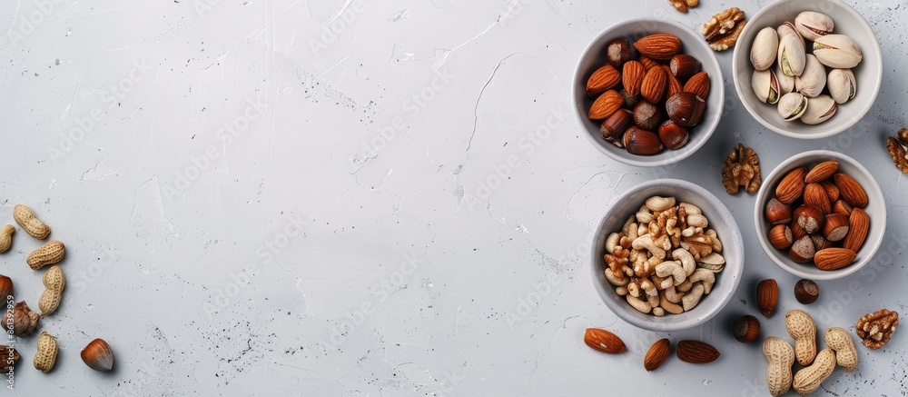 Poster White table with an overhead view displaying a variety of nuts, creating a healthy snack concept with space for text or images. copy space available