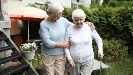 Elderly woman with her caregiver at nursing home
