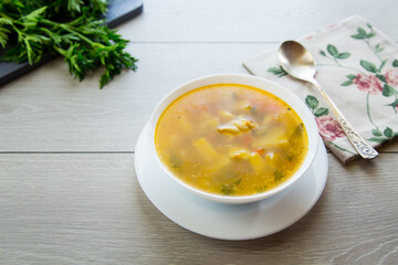 Homemade chicken vegetable soup on rustic wooden background