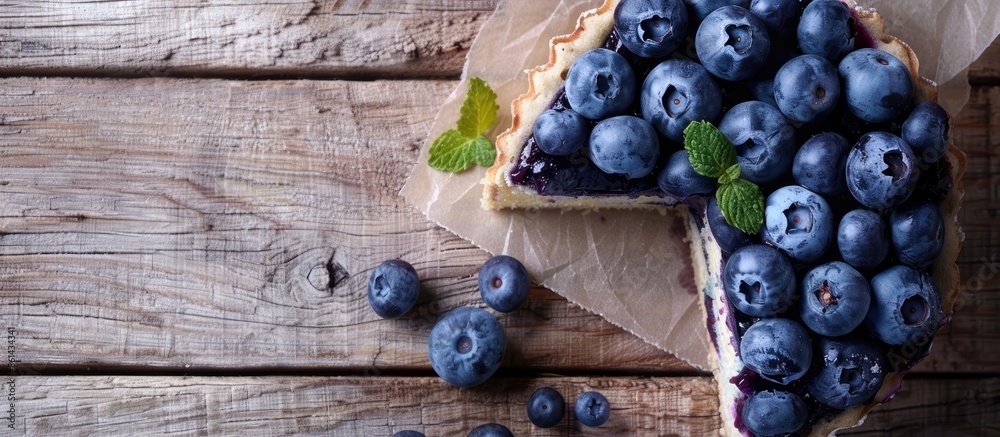 Poster Blueberry cake on a wooden table with room for text in a flat lay composition. image with copy space