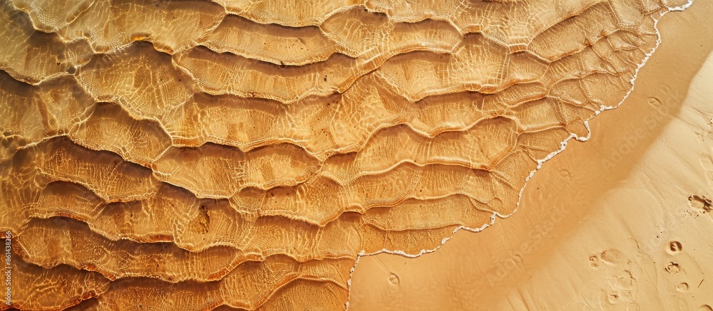 Poster Aerial view of a sandy beach with undulating patterns. Ideal summer backdrop with plenty of copy space image.