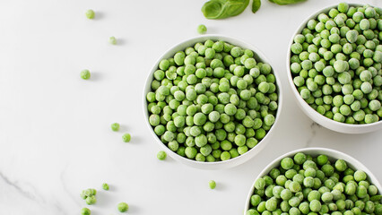Three bowls of frozen green peas on a marble surface. Healthy vegetables