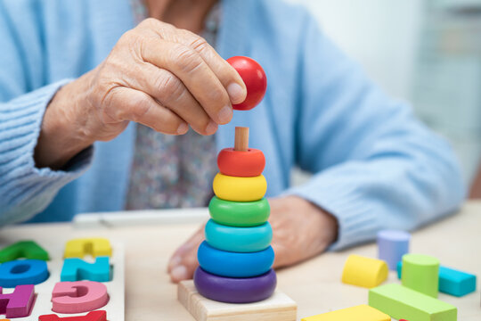 Alzheimer disease AD, Asian elderly woman patient suffering from dementia learn practical motor skills rehabilitation.
