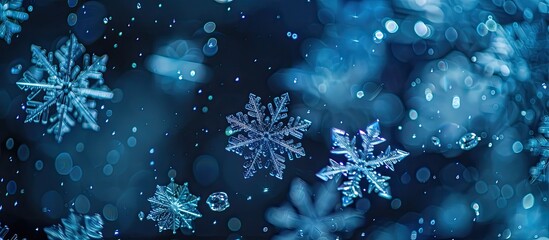 Snowflakes in white and blue hues look aesthetically pleasing against a dark background, creating a mesmerizing copy space image.