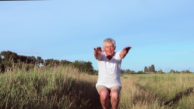 Elderly man enjoying his retirement by engaging in outdoor activities squatting preparing for running or workout engaging in regular physical activities