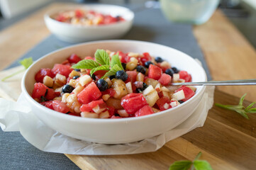 Homemade food with a fresh fruit salad. Made with melon, banana, apples, kiwi and blueberries  in a bowl 