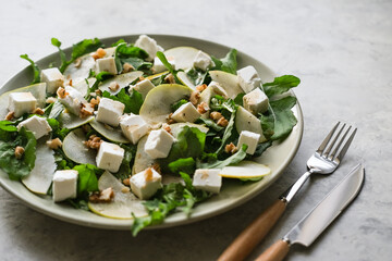 Salad with arugula, pear, feta cheese and walnut