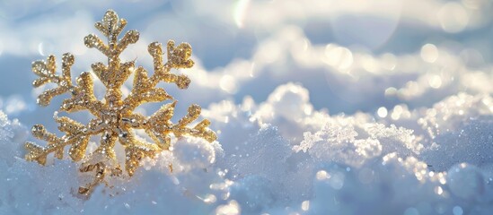 A shiny gold snowflake adorned with sparkling details rests on icy winter snow in a picture featuring an empty area for text or visuals. image with copy space
