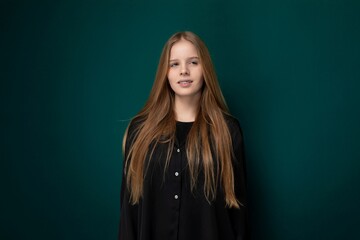 Young Girl Standing in Front of Green Wall