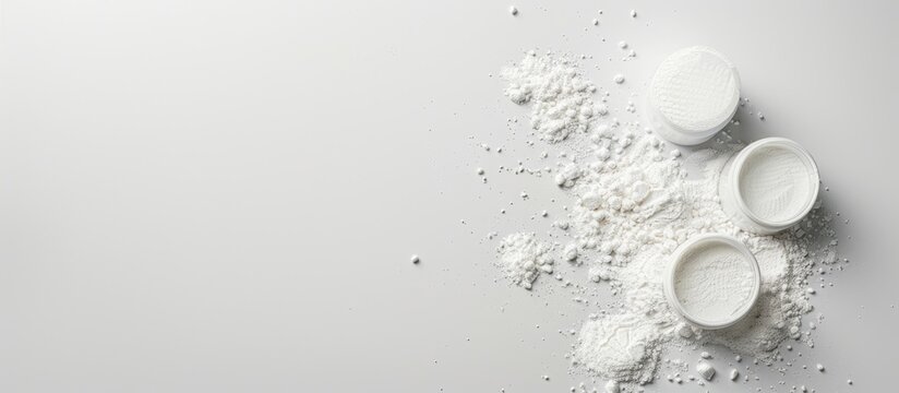 A collection of spilled baby powder containers on a blank white backdrop, with copy space image available.