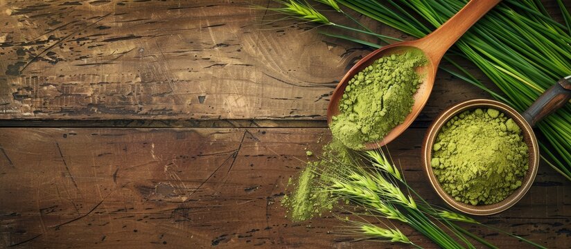 A wooden background showcasing barley grass powder, fresh blades, and room for a copy space image.