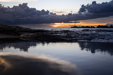 Clouds reflected in the sky while there is a sunset at Nightcliff Beach Darwin NT Australia.