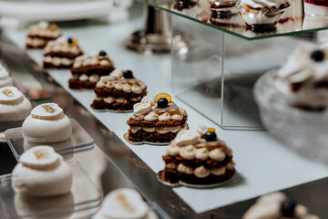 A display of small cakes with blueberries and cream