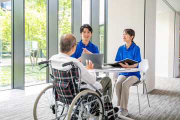 カウンセリングする介護スタッフとシニア男性