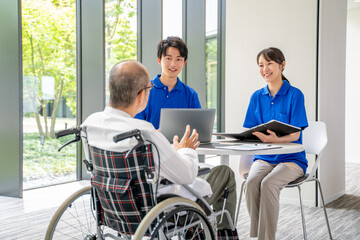 カウンセリングする介護スタッフとシニア男性