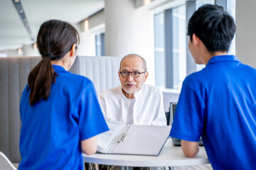 カウンセリングする介護スタッフとシニア男性