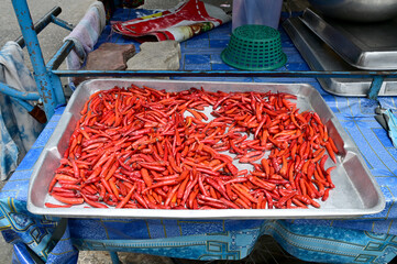 Closeup of Many of Fresh red chillies drying in a silver tray background at Thailand.