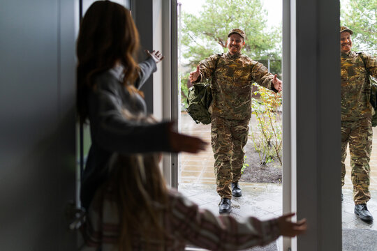 Smiling soldier receiving a warm welcome from his family