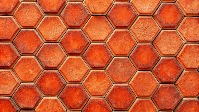 Hexagonal terracotta tiles with a red texture, forming a seamless and rustic pattern, ideal for backgrounds and architectural designs.