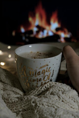 cozy cup of coffee in winter with fireplace on background