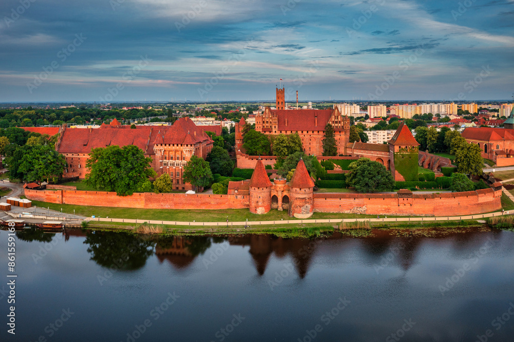 Wall mural Castle of theTeutonic Order in Malbork by the Nogat river at sunset.