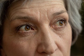 Close-up shot of a woman's eye. The woman has wrinkles around her eye and grey hair.