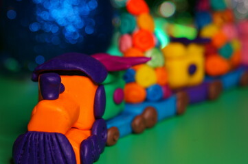 A toy train with plasticine gifts. Christmas background. New Year's holiday.