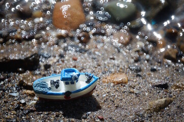 A small toy boat on the riverbank. A sea cruise. Journey.
