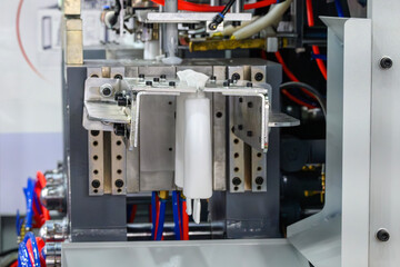 Fototapeta premium The white bottle container manufacturing process by blow mold machine.