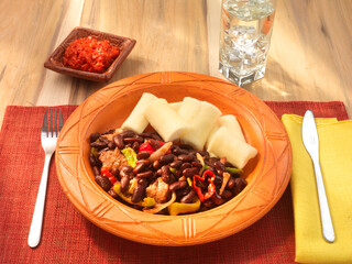 Red beans casava auf Terrakotta Teller und rostrotem Tischset, Westafrika, Ghana, afrikanisches Essen, Gemüse, 
