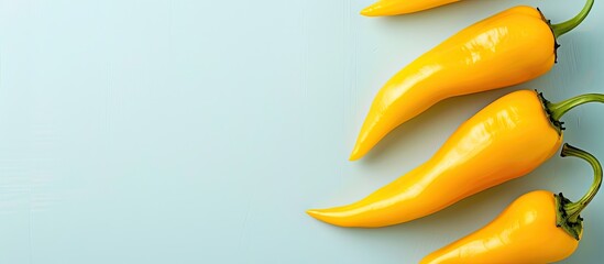 Built abreast yellow hot peppers on empty pastel background. with copy space image. Place for adding text or design