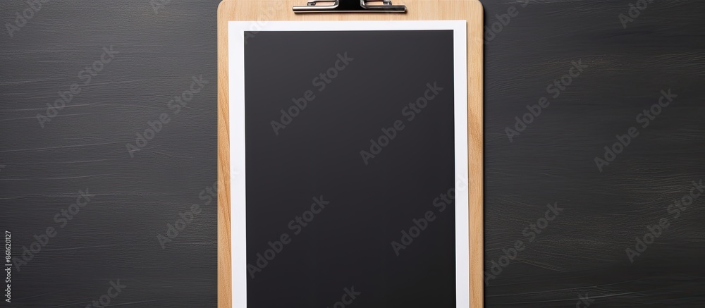 Poster close-up view of a clipboard with a blank paper, set against a dark gray background with copy space 