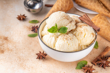 Indian cold summer Garam Masala Gelato dessert, Indian Three Spice Ice Cream in white ceramic bowl, with mint leaves,  spices and waffle ice cream cones