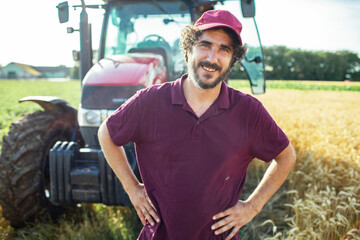 Portrait of a middle aged male farmer on field with tractor