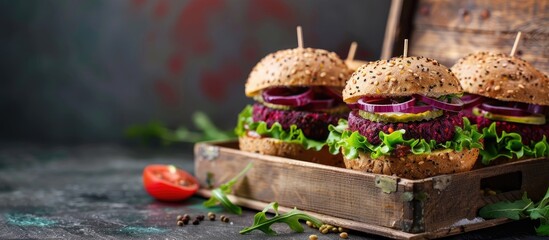 Vegan beet chickpea burgers with vegetables, guacamole and rye buns in wooden box. Healthy vegan food concept. Copy space image. Place for adding text or design