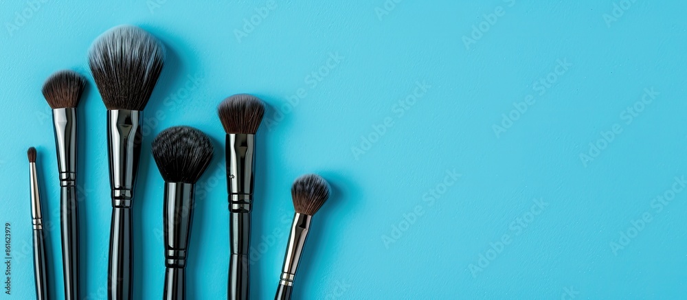 Poster makeup brushes for eyeshadow on a blue backdrop with copy space image.