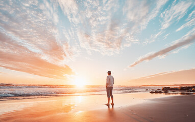 Fototapeta premium silhouette of a person on the shore of the beach contemplating a beautiful sunset