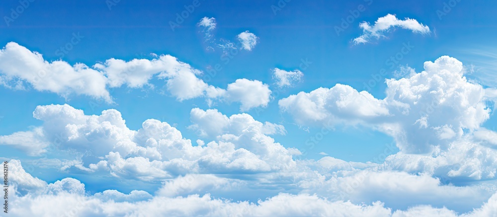 Poster the expansive blue sky filled with fluffy white clouds creates a serene copy space image.