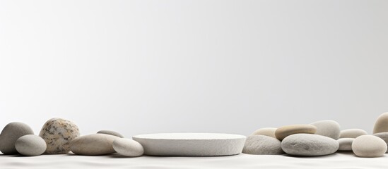 Podium or platform made of pebble stones used as a mock-up to display your product with a white background for copy space image.