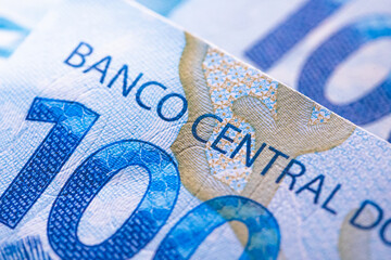Real - BRL. Uma nota de 100 reais vista pelo verso mostrando o texto referente ao Banco Central do...