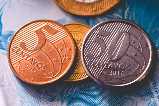 Moedas brasileiras sobre uma nota de 100 reais em fotografia macro. Economia brasileira e infla&ccedil;&atilde;o. Real - BRL, dinheiro, Brasil.