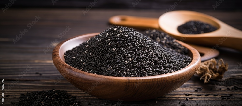 Fototapete Black sesame seeds spice arranged in a pile on a black wooden surface with an available area for additional content, like a copy space image.