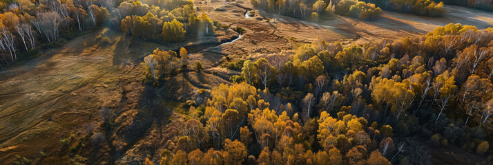 Naklejka premium Aerial panorama of an open landscape dotted with patches of forests in mid-autumn transition.