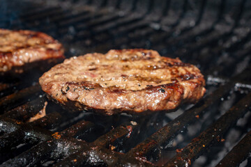 Homemade burger patty on a gas grill.  Ready to eat.
