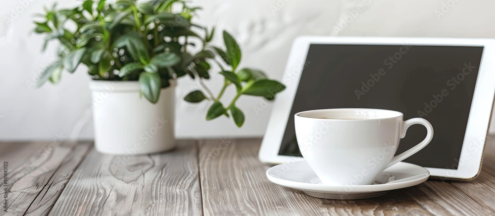 Poster Office desk with a tablet PC placed next to a white coffee cup, showing an empty space for an image. with copy space image. Place for adding text or design