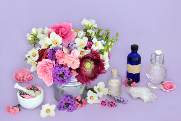 Flower and herb preparation for aromatherapy and natural herbal medicine. Flower essences with quartz crystal for alternative remedies on lilac background.